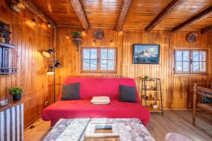 a red couch in a room with wooden walls at Chalet les aiguilles in Albiez-Montrond