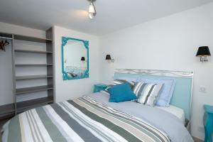 a bedroom with a blue and white bed and a mirror at Le Balcon des Bauges in La Motte-Servolex +24 photos