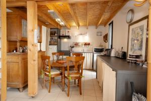 a kitchen with a table and chairs in a room at Le Balcon des Bauges in La Motte-Servolex