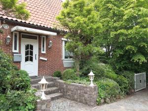 a brick house with a white door and a brick wall at Ferienhaus von Osten in Burg