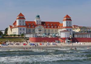 a group of people on a beach in front of a building at Haus Frohsinn - Wohnung 3 in Binz