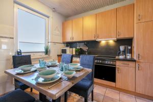 a kitchen with a wooden table with bowls and chairs at Ferienhaus von Osten in Burg
