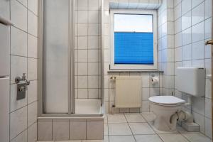 a bathroom with a toilet and a shower and a window at Haus Frohsinn - Wohnung 3 in Binz +17 photos