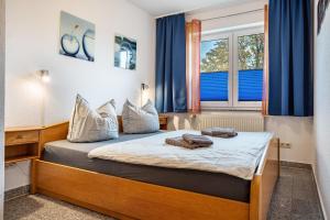 a bedroom with a bed with blue curtains at Haus Frohsinn - Wohnung 3 in Binz