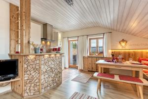 a kitchen with a wooden ceiling and a table at Ferienwohnung Geierstein in Wackersberg +18 photos