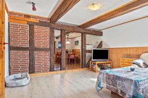 a living room with a brick wall and a television at Ferienwohnung Spormann in Braunlage