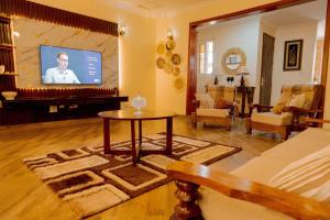 a living room with a tv and a table and a couch at Rhovee Homes in Moshi