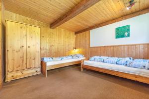 two beds in a room with wooden walls at Ferienwohnung Spormann in Braunlage