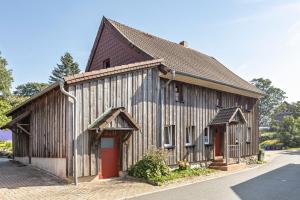 a large wooden building with a red door at Ferienwohnung Spormann in Braunlage