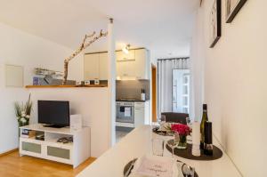 a living room with a table and a kitchen at Ferienwohnung in ruhiger Lage in Überlingen