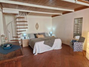 a bedroom with a large bed and a staircase at Piccolo Paradiso - Riparbella in Riparbella +52 photos