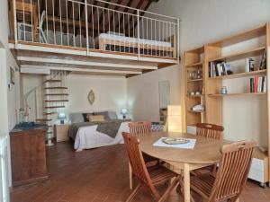 a living room with a table and a bedroom at Piccolo Paradiso - Riparbella in Riparbella