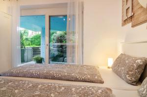 a bedroom with a bed and a large window at Ferienwohnung in ruhiger Lage in Überlingen
