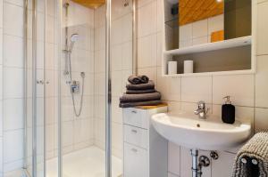 a white bathroom with a shower and a sink at Ferienwohnung in ruhiger Lage in Überlingen