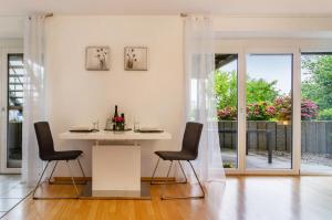 a white dining room with a table and chairs at Ferienwohnung in ruhiger Lage in Überlingen +12 photos