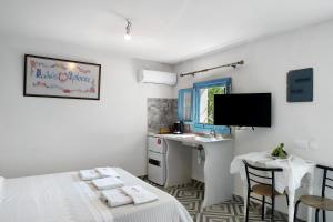 a bedroom with a bed and a desk and a sink at Politimi Studio N8 in Amorgos