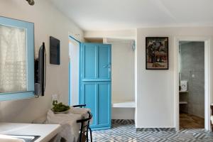 a bathroom with a blue door and a tub at Politimi Studio N8 in Amorgos
