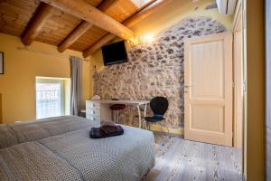 a bedroom with a bed and a desk and a door at Appartamento Gufo in Tremosine Sul Garda