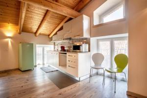 a kitchen with a green refrigerator and two chairs at Appartamento Gufo in Tremosine Sul Garda
