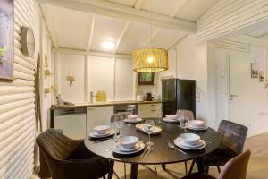a dining room with a table and chairs and a kitchen at Berghütte in Ulrichstein