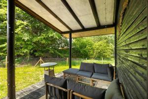 a covered patio with a couch and a table at Berghütte in Ulrichstein