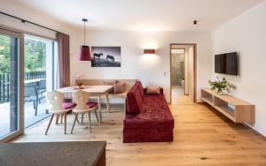 a living room with a red couch and a table at Gostnerhof Barbian in Barbiano