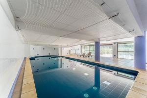 an indoor swimming pool with a large ceiling at Appartement des Cedres in Uzès