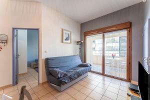 a living room with a couch and a sliding glass door at Appartement des Cedres in Uzès
