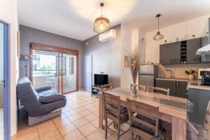 a kitchen and living room with a table and a couch at Appartement des Cedres in Uzès