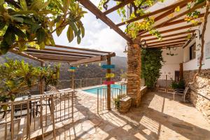 a villa with a swimming pool and a pergola at Tenguerengue in Laroya