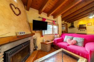 a living room with a red couch and a fireplace at Tenguerengue in Laroya