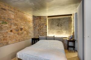 a bedroom with a bed and a brick wall at Modern Heritage House in Imperia