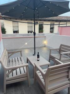 two chairs and a table with an umbrella on a patio at Il Paradiso Holiday in Ravenna