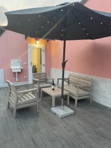 a patio with benches and a black umbrella at Il Paradiso Holiday in Ravenna