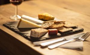 eine Platte mit Käse und Brot und ein Glas Wein in der Unterkunft Gales Of Llangollen in Llangollen
