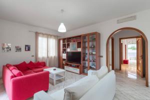 a living room with a red couch and a tv at Appartamento in Villa Marlory in Monreale