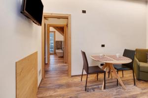 a dining room with a table and chairs and a television at Olympic Chalet 12 in Bormio