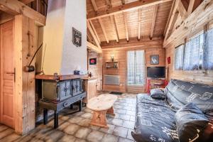 a living room with a couch and a stove at Chalet 4p Classique-Les Ancolies in Verchaix