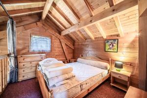 a bedroom in a log cabin with a bed at Chalet 4p Classique-Les Ancolies in Verchaix