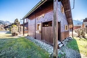 a wooden cabin with a door in the yard at Chalet 4p Classique-Les Ancolies in Verchaix