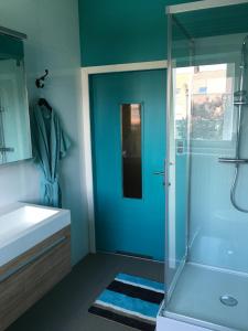 baño azul con ducha y lavamanos en Bella Noche Brugge, en Brujas