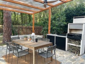 a patio with a wooden table and chairs and a grill at Bacom Apartment in Caldes de Malavella