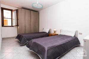 a bedroom with two beds and a window at Malamuri 4 sun vacanze in Budoni +14 photos