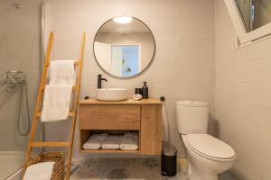 a bathroom with a toilet and a sink and a mirror at Bacom Apartment in Caldes de Malavella +35 photos