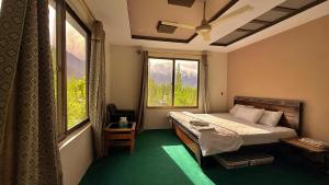 a bedroom with a bed and a large window at Flora Inn Skardu in Skardu +27 photos