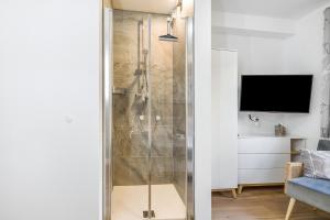 a shower with a glass door in a bathroom at Ferienwohnung Edelstein in Neukirchen am Großvenediger +28 photos