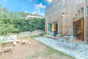a patio with a table and chairs in front of a house at Bacom Apartment in Caldes de Malavella