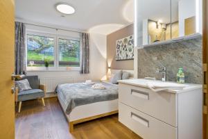 a small bedroom with a bed and a sink at Ferienwohnung Edelstein in Neukirchen am Großvenediger