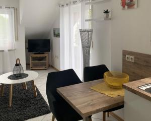 a living room with a table and chairs and a television at Haus Zum Haiden in Bodman-Ludwigshafen