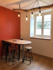 a table and stools in a room with a window at Gîte Bonaty in Soulgé-sur-ouette